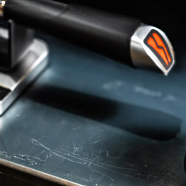 Automatic coffee tamper beside espresso portafilter before tamping